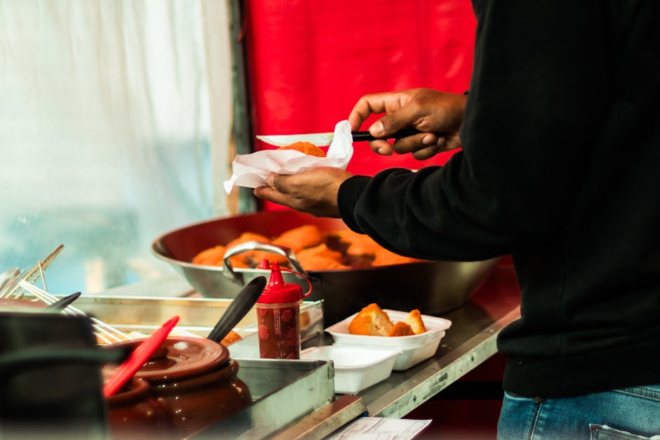 Hände eines Verkäufers in Bari legen frittierte Kroketten in Schale