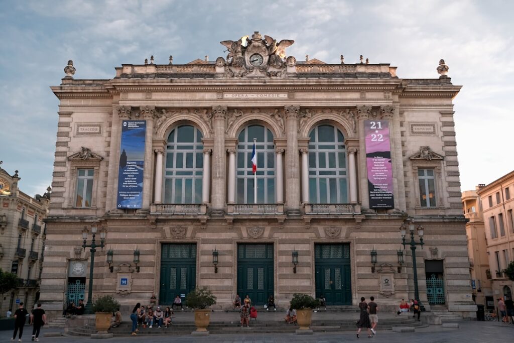 Klasyczny gmach teatru w Bari z ludźmi siedzącymi na schodach