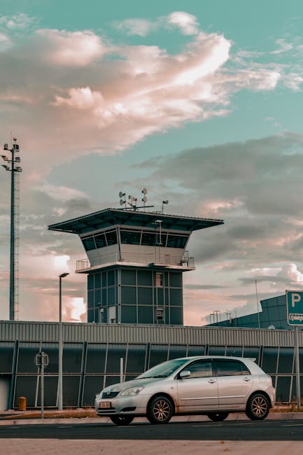 Parkerende auto bij verkeerstoren van luchthaven Bari met wolkenlucht