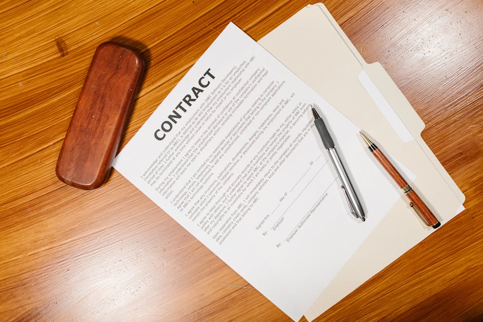 contrat de location posé sur bureau en bois avec deux stylos