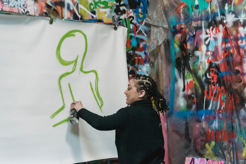 Artiste en train de peindre au spray dans un atelier urbain à Bari