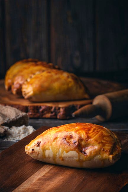 Comparison of a fried panzerotto and a baked panzerotto on a rustic board