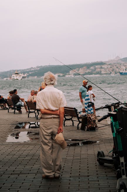 Anziano in camicia osserva il mare sul lungomare di Bari