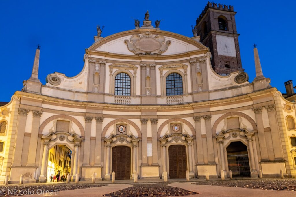 Kirchenfassade bei Abenddämmerung mit Torbögen und Glockenturm in Bari.