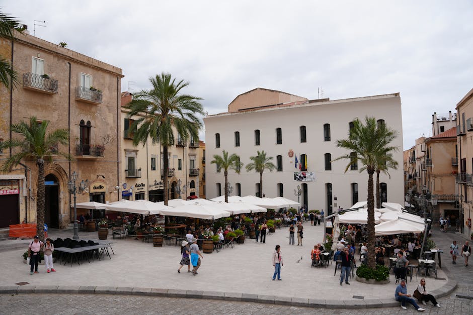 Busy Bari piazza with outdoor cafes, palm trees and shaded tables