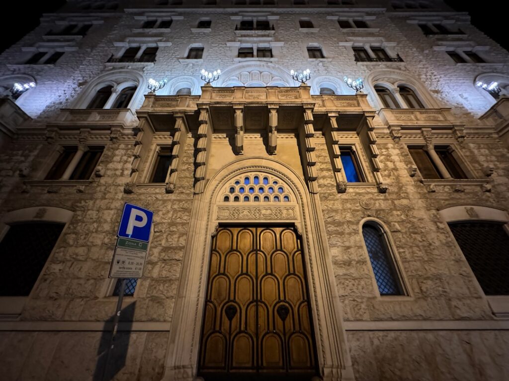 Façade en pierre éclairée la nuit à Bari, porte en bois imposante