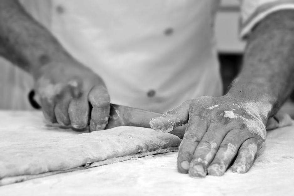 Mains farinées d’un boulanger découpant la pâte à Bari