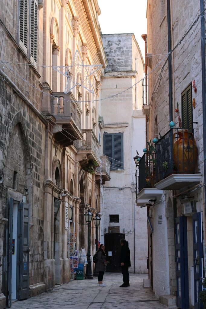 Narrow stone alley in Bari old town with two people talking