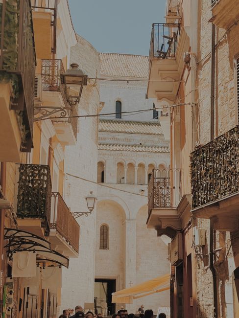 Narrow Bari alley framed by balconies leading to San Nicola Basilica entrance