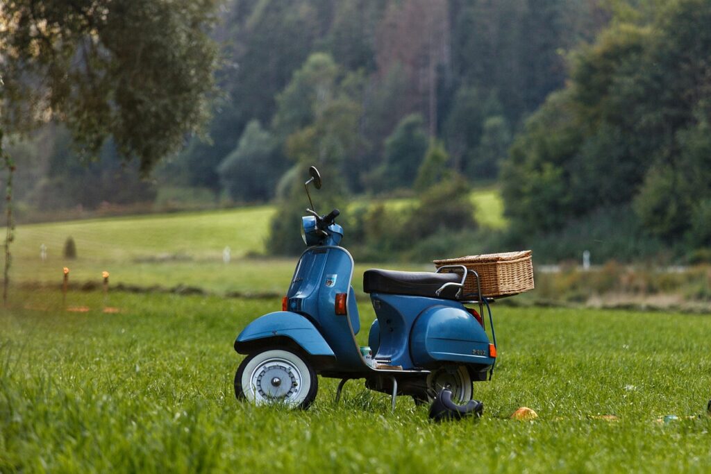 Vespa auf Wiese, Picknickkorb hingestellt, ländliche Umgebung bei Bari