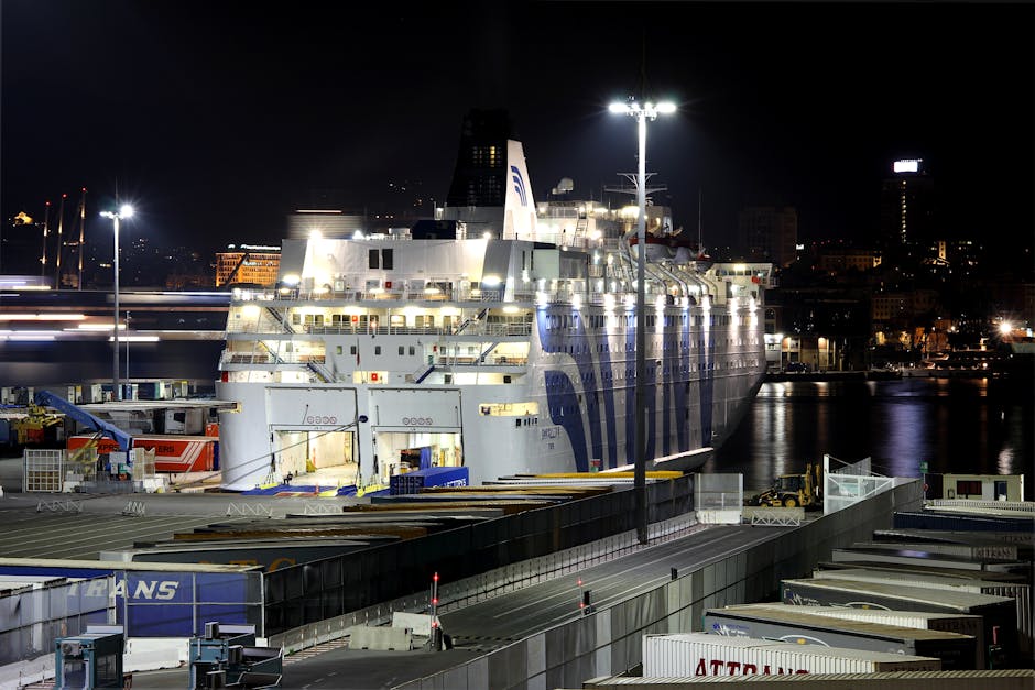 Illuminated ferry docked at Bari port under nighttime lights