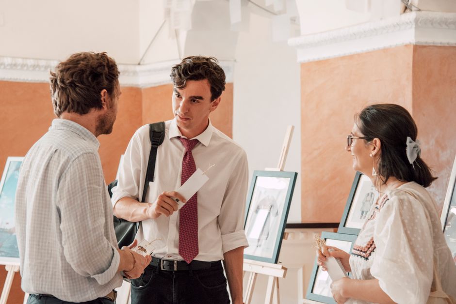 group of visitors enjoying an art gallery talk in an Italian coastal city