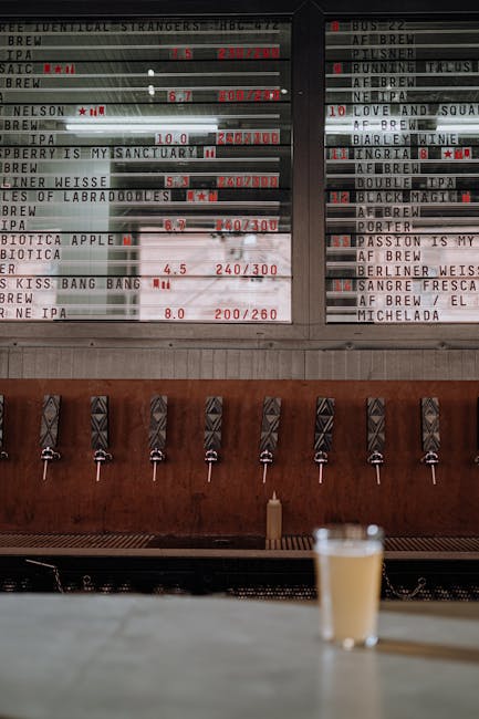 Tireuses et ardoise des bières, verre posé au bar à Catane