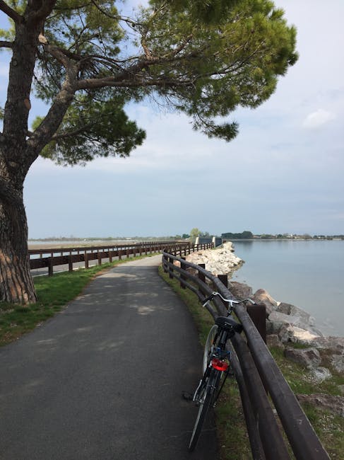 Gepflasterter Küstenweg mit Fahrrad am Geländer und Meer bei Catane