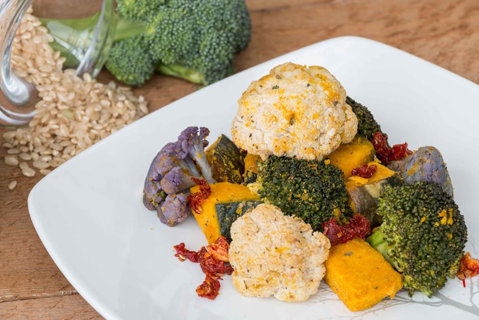 Platter of roasted vegetables and rice balls on a white plate.