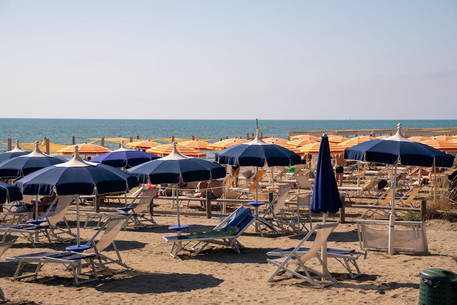 Rangées de parasols bleus et orangés sur plage de Catane