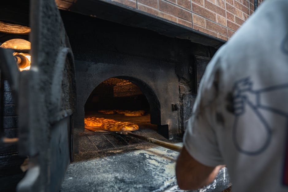 Focacce calde in cottura dentro il forno, fornaio in azione
