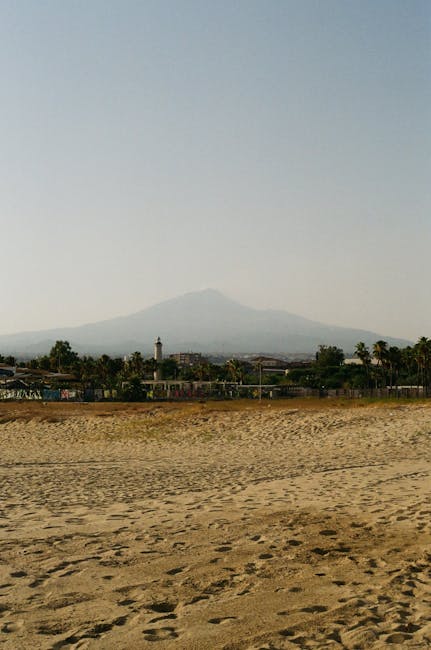 Plage de sable à Catane avec l'Etna en arrière-plan brumeux