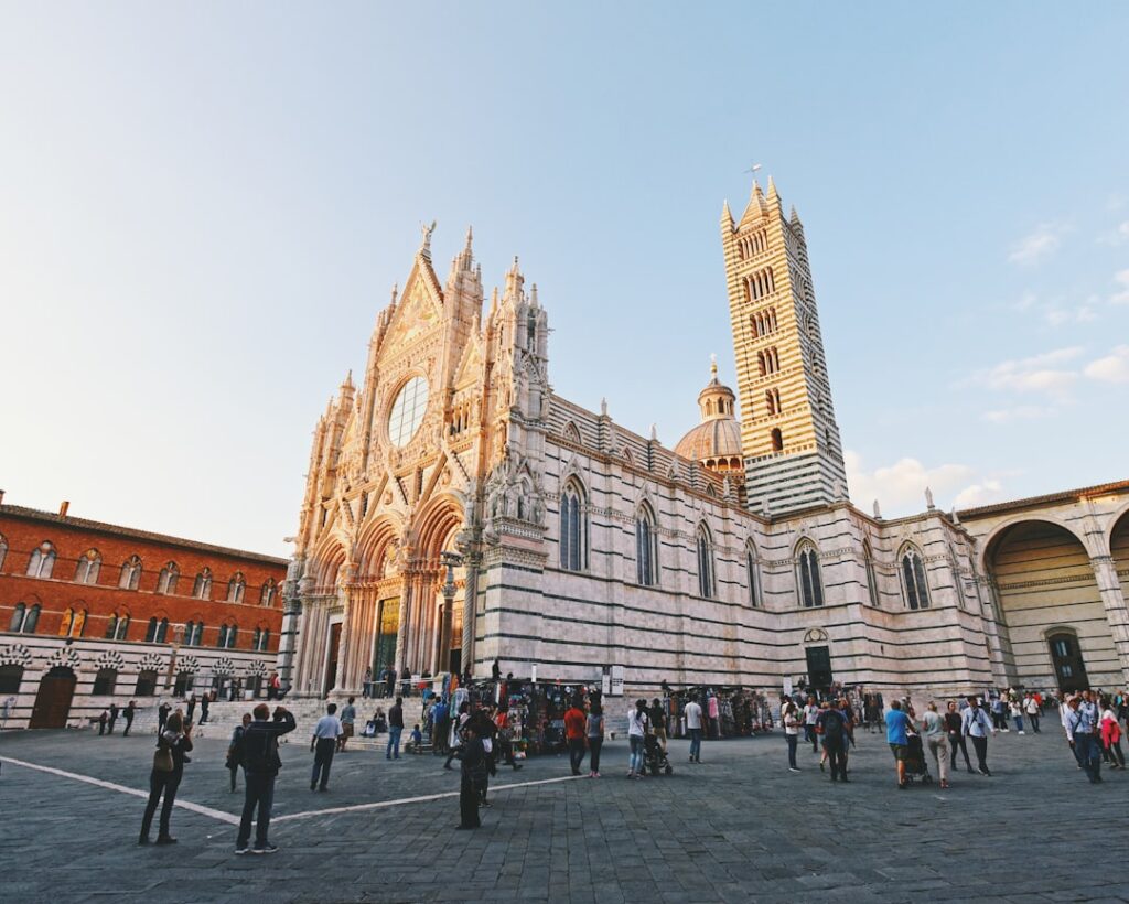 Cattedrale gotica con facciata marmorea e turisti in piazza