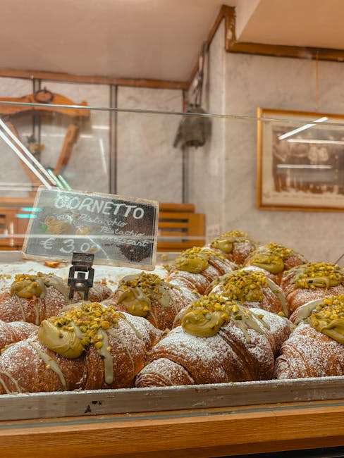 Pistachio-topped cornetti on display in a Catania bakery case