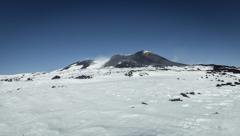 Schneefläche und dunkle Lavaspitzen am Ätna nahe Catania