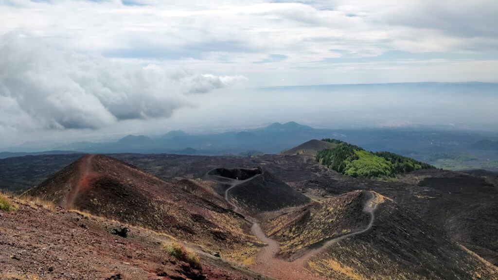 Vulkanische Kraterlandschaft mit Wegen und Fernblick auf Catania