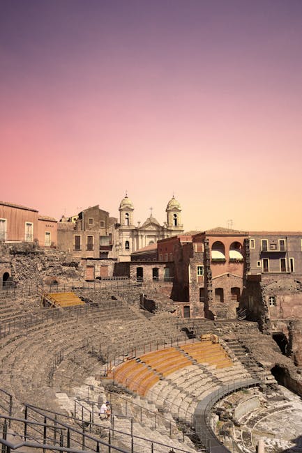 Ruïnes van het oude amfitheater in Catania tegen gekleurde hemel