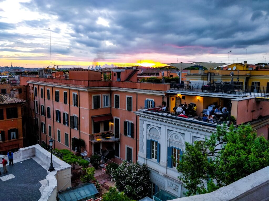 Rooftop terrace overlooking orange buildings and sunset in Catania