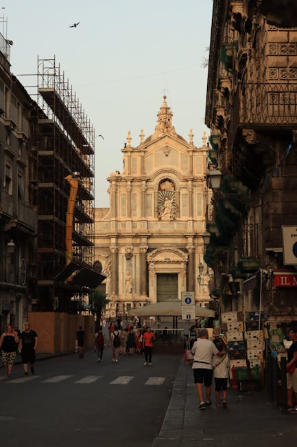 Straat in Catania met voetgangers en de kathedraal op de achtergrond
