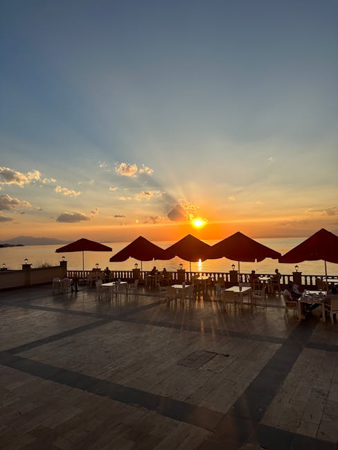 Terrazza sul mare di Catania al tramonto con ombrelloni rossi