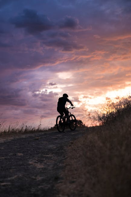Radfahrer vor Sonnenuntergang mit Ätna-Silhouette