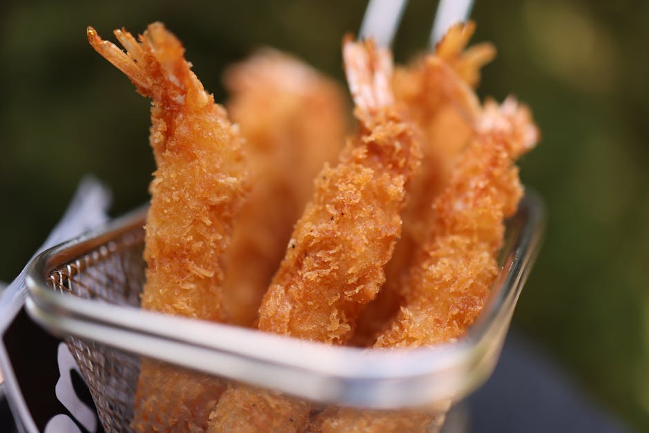 Crispy breaded prawns in a metal basket, typical Catania takeaway