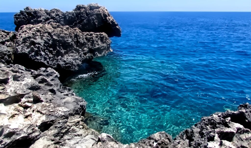 Scogliera con acqua cristallina del Mediterraneo vicino Catania