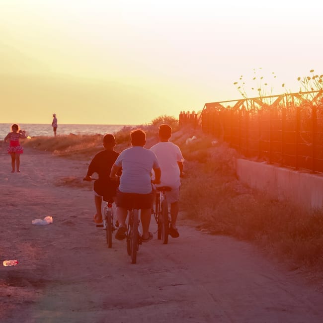 Famiglia che pedala insieme sulla strada costiera di Catania