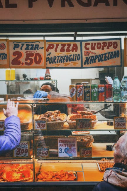 Straattent met gefrituurde snacks en prijslijst, klant wijst naar eten
