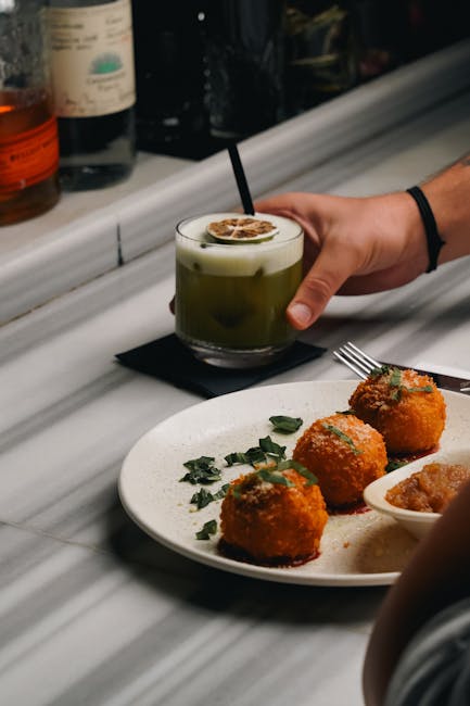 Drie arancini op bord met chutney, bar in Catane op de achtergrond