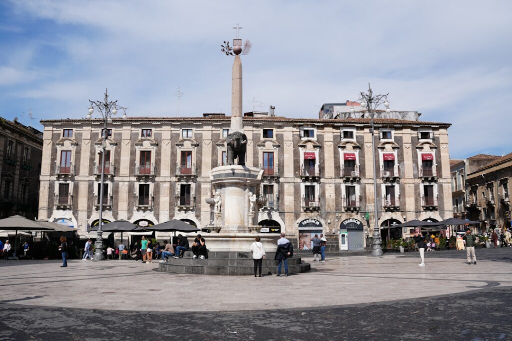 Grupa przyjaciół jedzących uliczne jedzenie na Piazza Duomo w Katanii