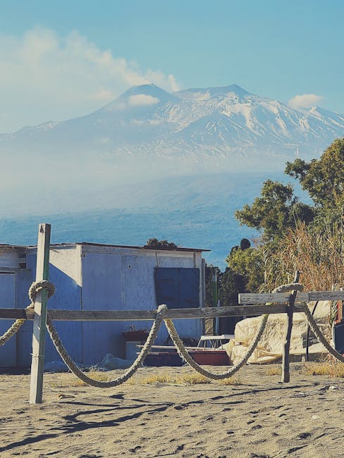 Plage sablonneuse et palissade en corde, l'Etna visible près de Catane