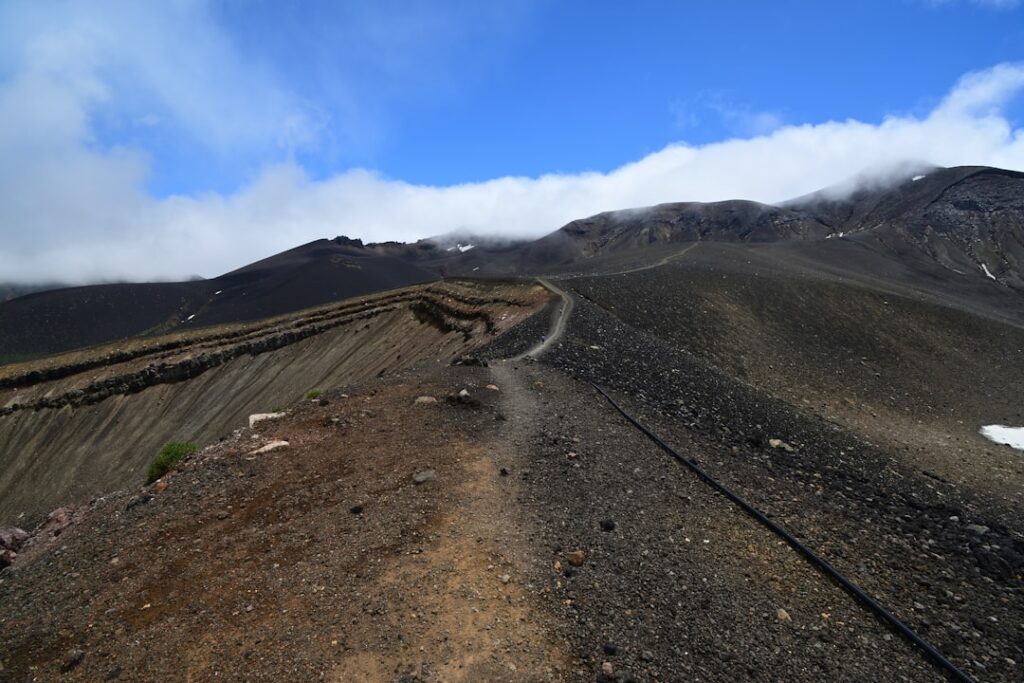 Sentier volcanique noir serpentant sur les pentes de l'Etna près de Catane