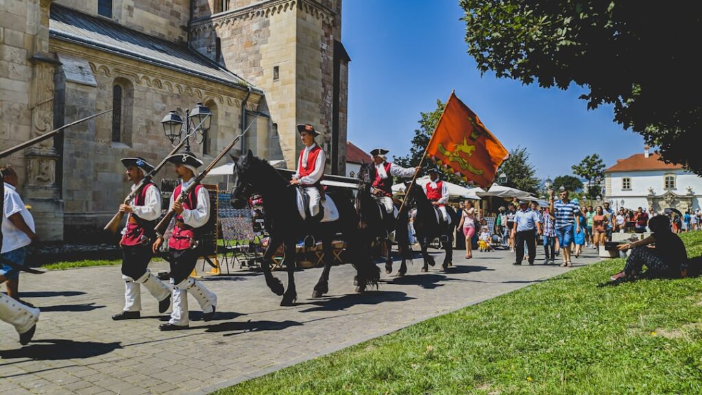 Sfilata storica con cavalieri e bandiere davanti a una chiesa in Piemonte