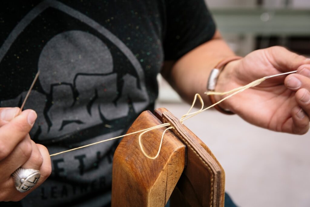 Artisan leatherworker stitching a bag