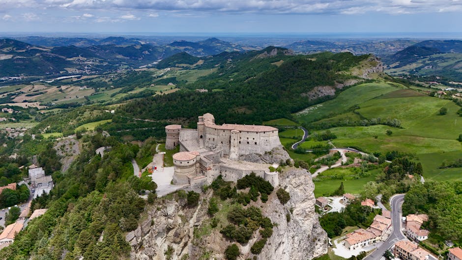 Ancient hilltop fortress above winding roads and green Piedmont countryside