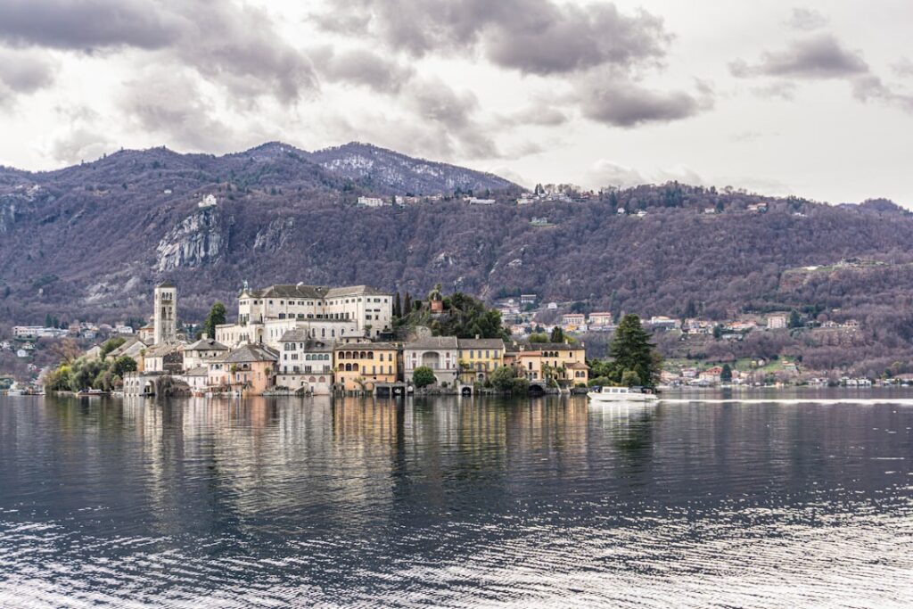 Wyspa San Giulio na Jeziorze Orta z zabudową i górami Piemontu
