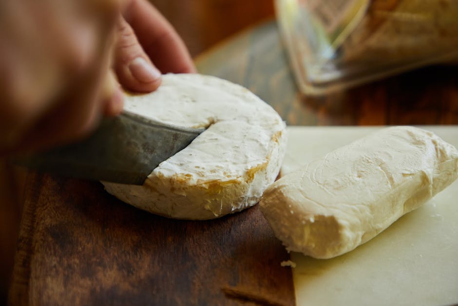 Traditional cheesemaker cutting a wheel