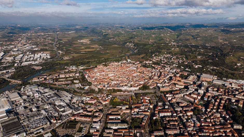 Vue aérienne d'une ville piémontaise entourée de vignobles et collines
