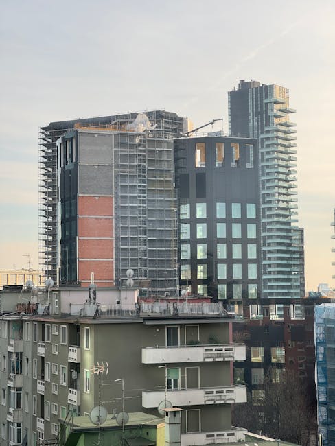 Grattacieli moderni e palazzi in costruzione contro cielo sereno