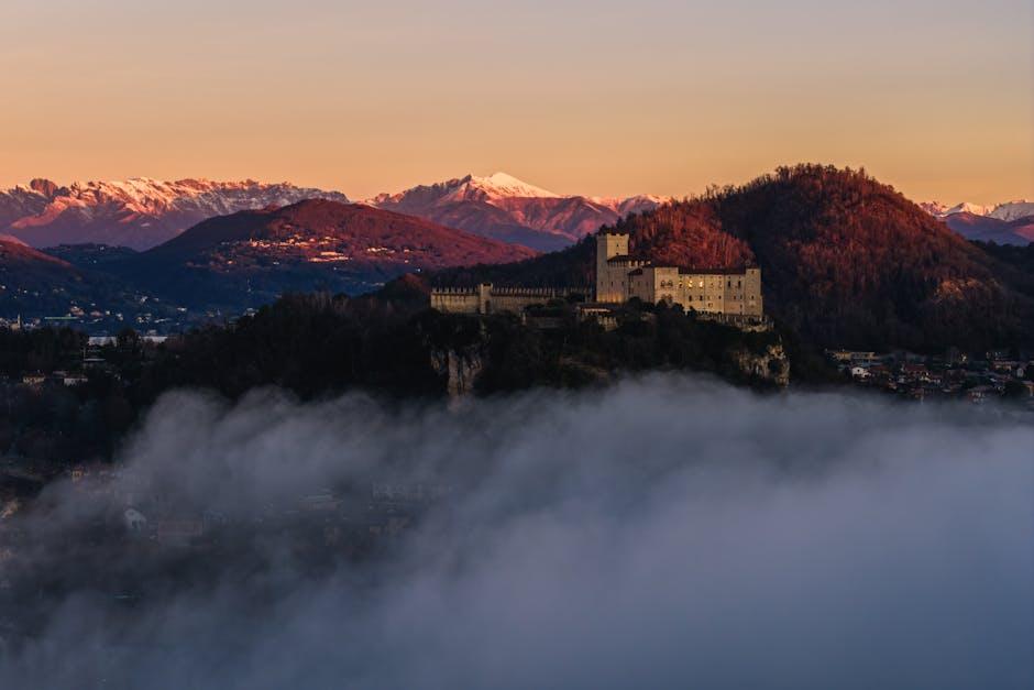 Castello sulle colline del Piemonte avvolto dalla nebbia all'alba