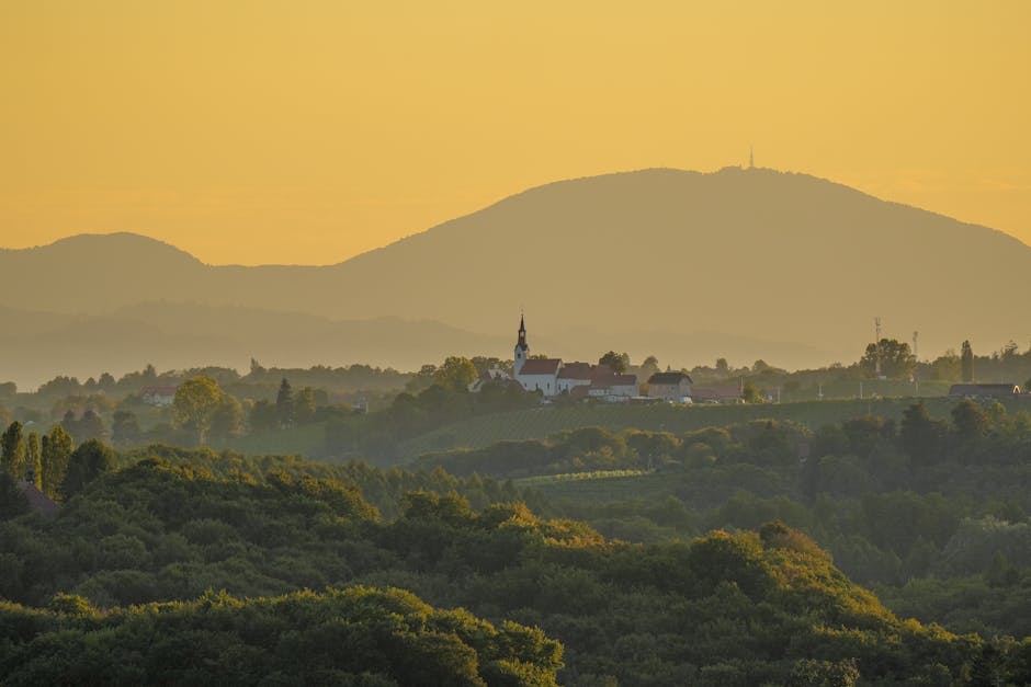 Chiesa rurale su collina con sfondo montuoso dorato in Piemonte