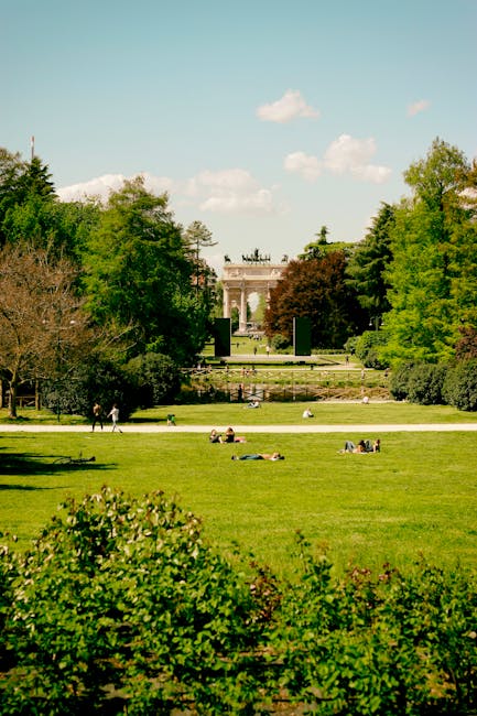 Park w Turynie z rozłożystą trawą i łukiem w oddali