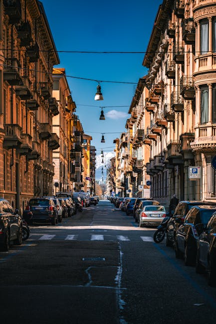 Rue urbaine bordée d'immeubles haussmanniens, vue sur les Alpes piémontaises